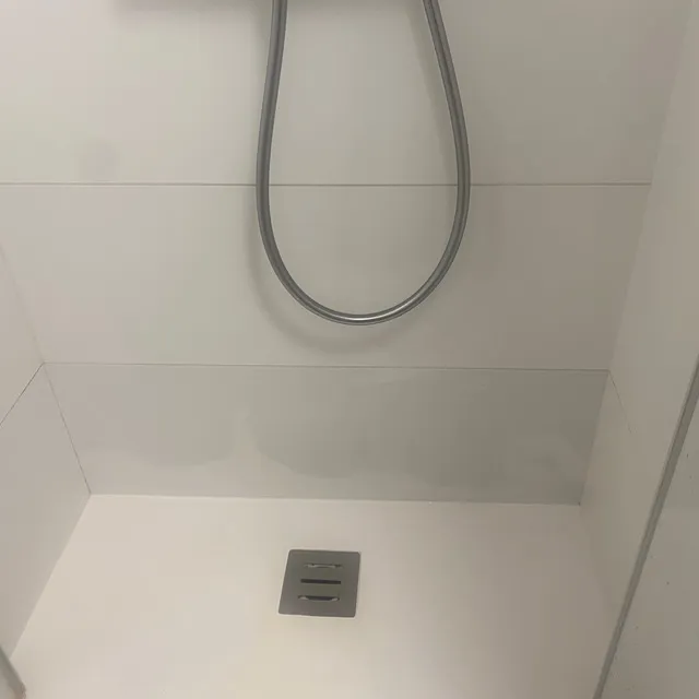 Carrelage de douche blanc devenu bleuté/gris